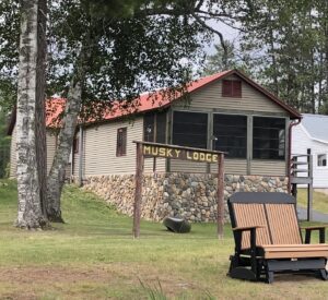 A wooden bench sitting in front of a cabin.