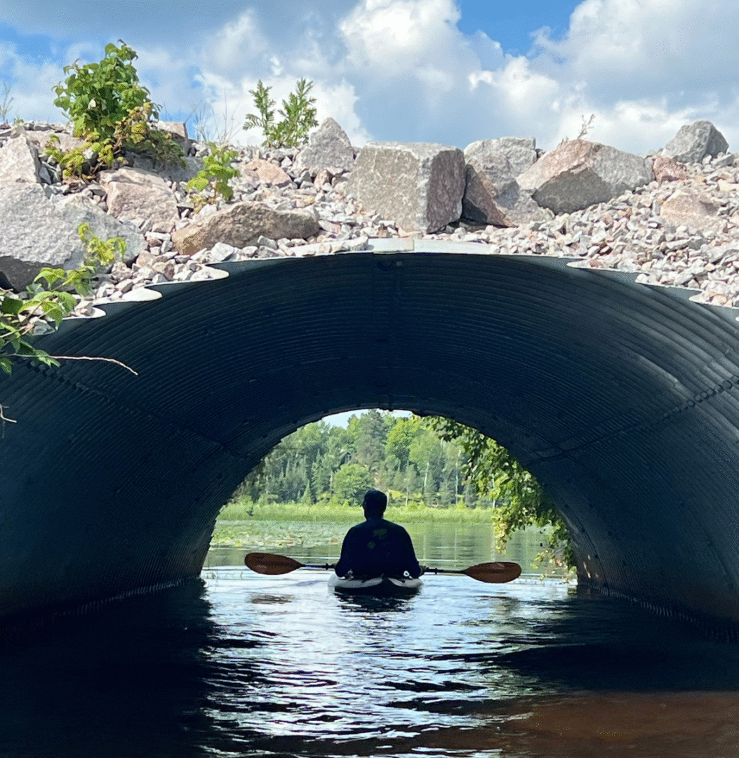 kayaker paddling under tunnel high lake musky lodge boulder junction Wisconsin