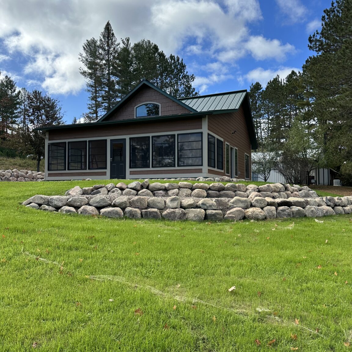 2023 Tamarack pic1 A house sitting on top of a hill with rocks around it.
